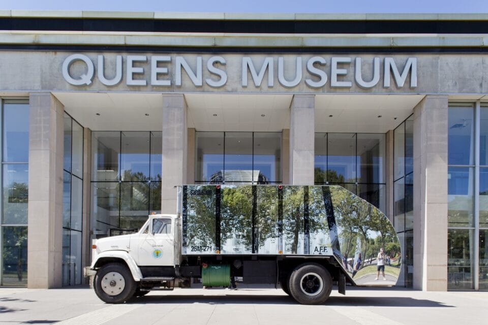 a mirrored garbage truck in front of the Queens Museum