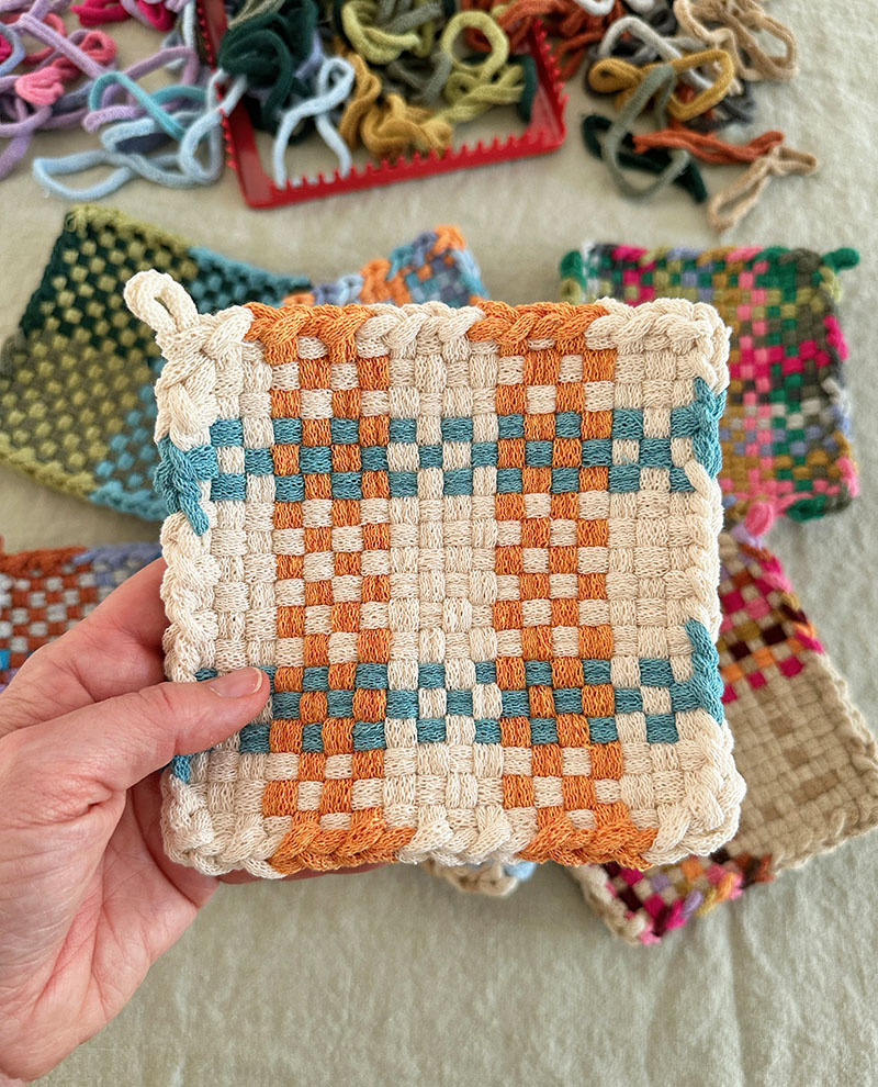 Finished potholder weaving in complimentary colors orange and blue.