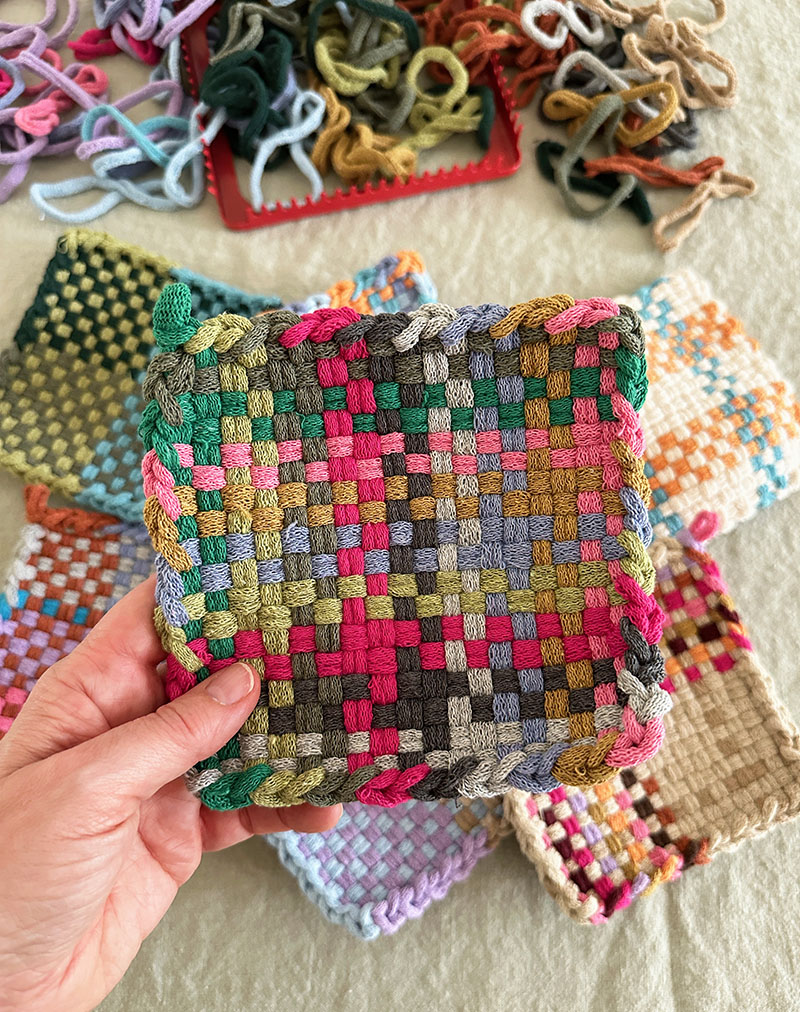 Finished potholder weaving in a multi-color muted bright palette.