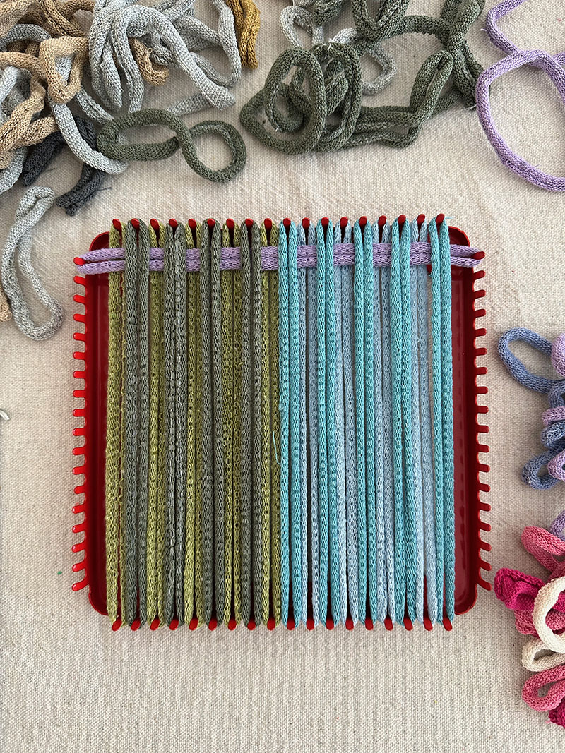 The first steps in weaving a potholder is looping the "weft" then starting your over and under from the top or bottom.