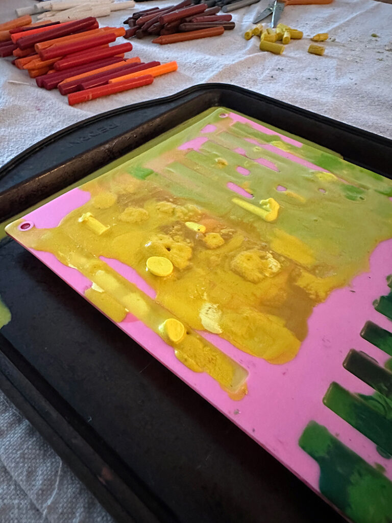 Melted wax overflowing a silicone mold on a tray.