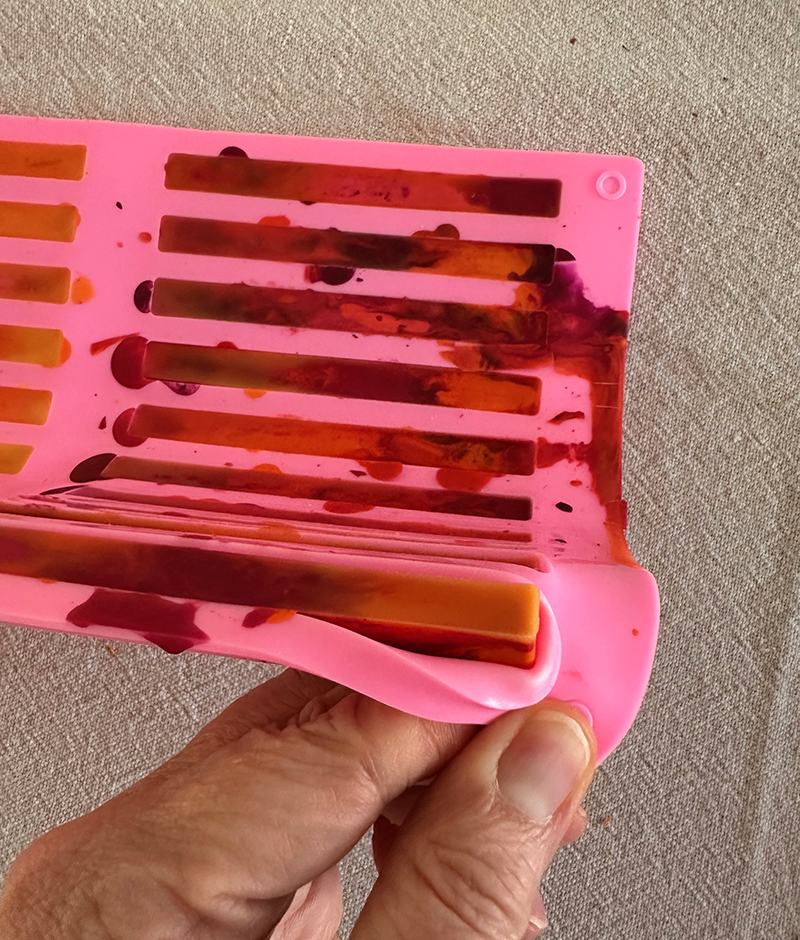 Taking homemade crayons out of a silicone mold.