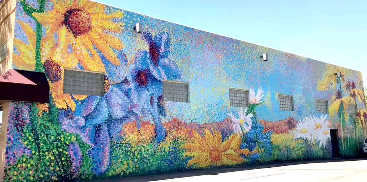 A coloful mural of flowers painted in a pointillism style.