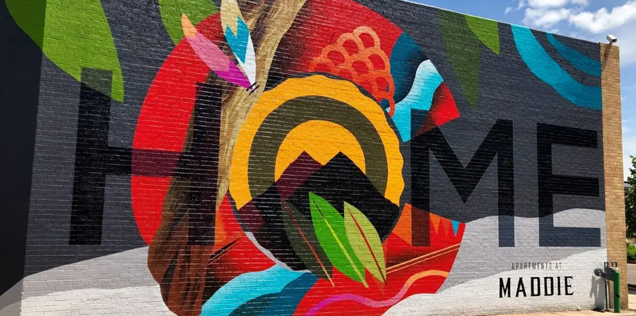 A colorful mural on a dark background with the word Home imposed over the Colorado C